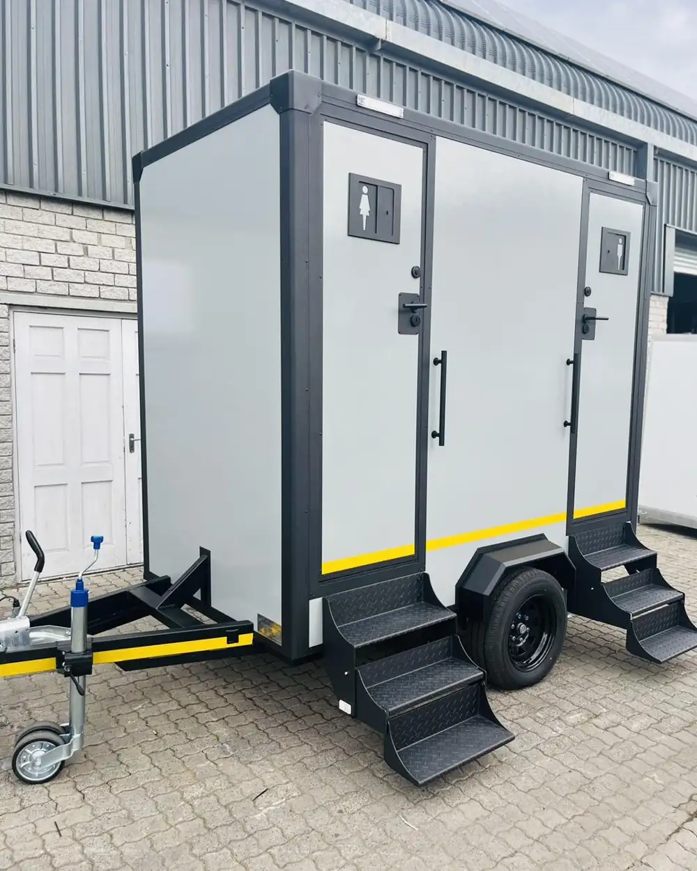 Two-stall restroom trailer with men's and women's doors and steps